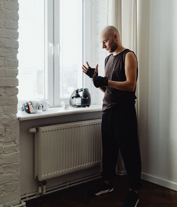 A focused man preparing for a strength training session, deep in thought.